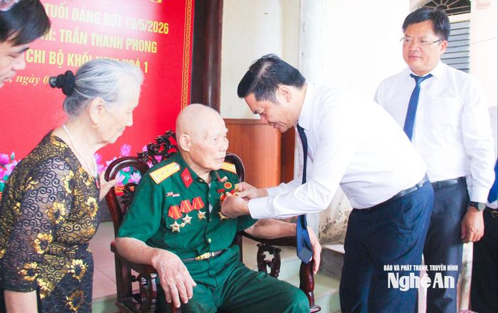 Đồng chí Hoàng Nghĩa Hiếu – Phó Bí thư Thường trực Tỉnh ủy, Chủ tịch HĐND tỉnh trao Huy hiệu 70 tuổi Đảng cho đồng chí Trần Thanh Phong, sinh hoạt tại Chi bộ khối Nghi Hòa 1, phường Cửa Lò. Ảnh: Mai Hoa