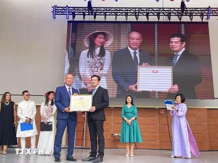 Đại sứ Phạm Trường Giang trao tặng Bằng khen Ủy ban Trung ương Mặt trận Tổ quốc Việt Nam cho Ban Chấp hành Hội người Việt Nam tại Slovakia. (Ảnh: TTXVN phát)