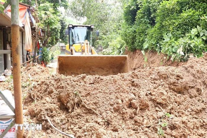 Các đơn vị giao thông thu dọn khu vực bị sạt lở để thông tuyến tại tỉnh lộ 137 qua địa bàn xã Nậm Mạ. (Ảnh: Nguyễn Oanh/TTXVN)