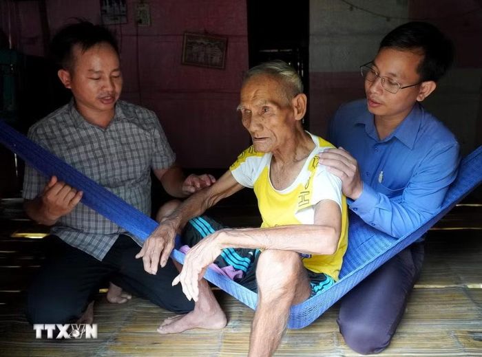 Ông Phạm Văn Lộc (78 tuổi), trú thôn Ba Lăng (Quảng Ngãi) không thể trực tiếp đi rút tiền vì tuổi cao, sức yếu. (Ảnh: Lê Phước Ngọc/TTXVN)