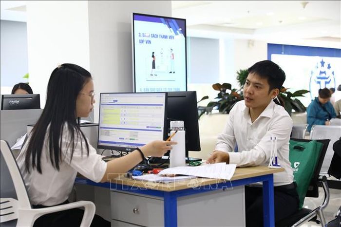Nhân viên tư vấn cho người dân đến làm thủ tục tại Trung tâm Phục vụ hành chính công thành phố Hà Nội. Ảnh: Quốc Lũy/TTXVN