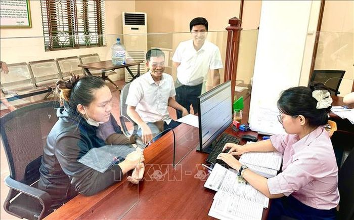 Cán bộ Ngân hàng Chính sách xã hội hoàn tất hồ sơ vay vốn cho khách hàng tại phường Đồng Văn (Ninh Bình).
