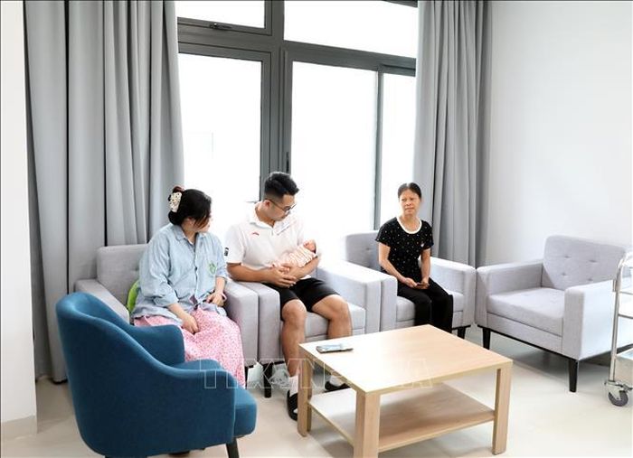 Gia đình chị Lương Thị Huyền (29 tuổi, Hà Nội) vui mừng đón thành viên mới của gia đình sau khi được mổ đẻ và chiếu tia plasma vết mổ can thiệp cho sản phụ tại Bệnh viện Bạch Mai cơ sở Ninh Bình. Ảnh: Thanh Tuấn/TTXVN