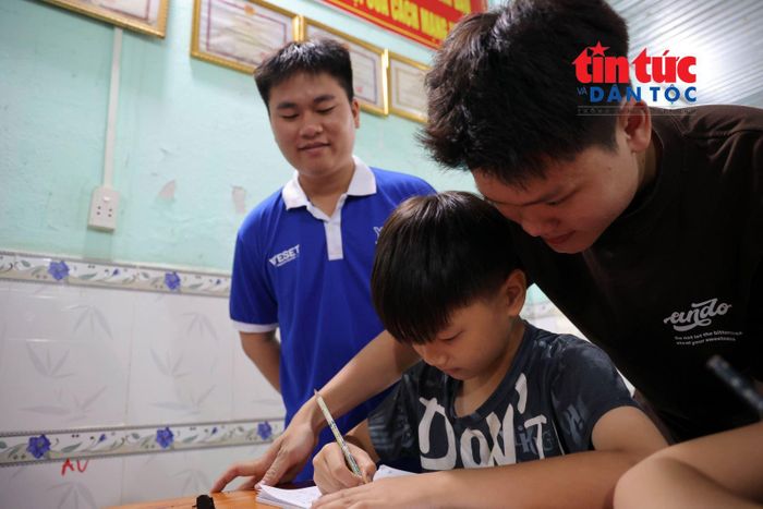 Các tình nguyện viên kèm dạy học cho Trần Minh Trí (10 tuổi).
