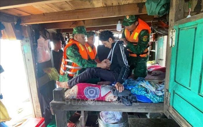 Lực lượng Quân y Đồn Biên phòng Quỳnh Thuận (Bộ đội Biên phòng Nghệ An) sơ cứu nạn nhân trên biển trước lúc đưa nạn nhân vào bờ để chuyển lên tuyến trên. Ảnh: TTXVN phát.