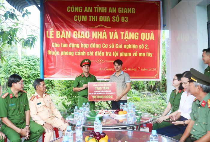 Đại tá Diệp Văn Thế, Phó Giám đốc Công an tỉnh An Giang, trao tặng kinh phí sửa chữa nhà cho anh Trần Hữu Phi.
