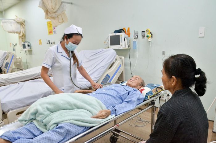 Điều dưỡng viên kiểm tra huyết áp cho bệnh nhân. Ảnh: MI NI