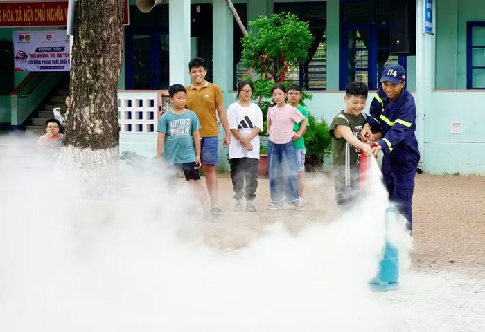 Trẻ em phường Quy Nhơn hào hứng khi được trực tiếp thực hành sử dụng bình chữa cháy cầm tay tại buổi sinh hoạt hè do Đoàn phường tổ chức. Ảnh: D.L