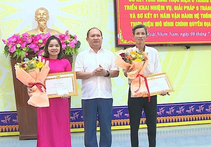 Đồng chí Rah Lan Chung tặng bằng khen của Ban Thường vụ Tỉnh ủy cho 2 đảng viên của Đảng bộ phường Hoài Nhơn Nam hoàn thành xuất sắc nhiệm vụ 5 năm liên tục. Ảnh: Trung Nghĩa