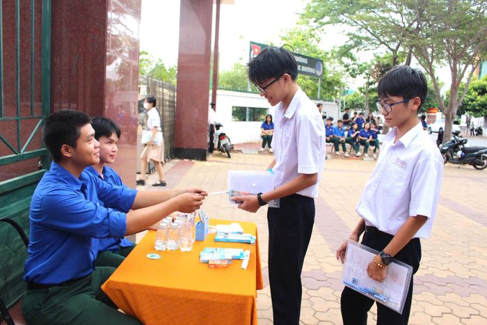 Đoàn viên thanh niên tình nguyện hỗ trợ thí sinh bút viết, nước...