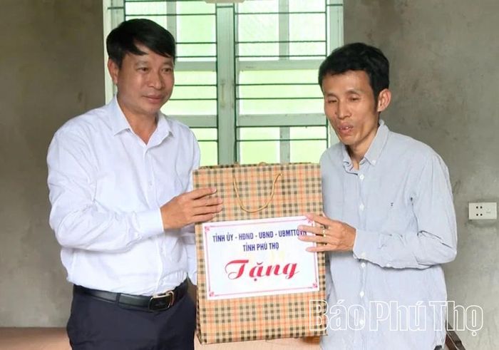Đồng chí Phó Chủ tịch UBND tỉnh Nguyễn Khắc Hiếu tặng quà cho gia đình ông Hà Văn Hiệp, xã Sông Lô.