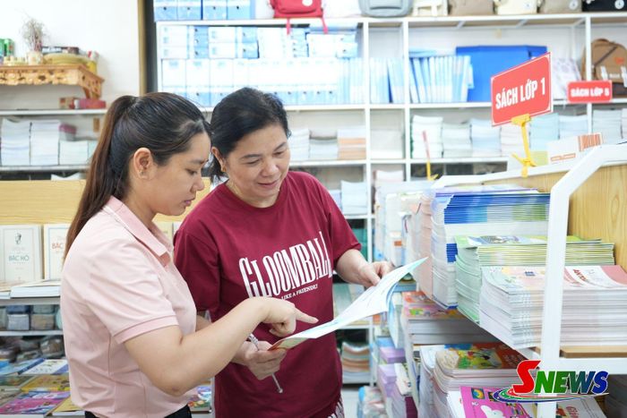 Nhân viên Nhà sách giáo dục, Công ty cổ phần Dịch vụ Thương mại Sách và Thiết bị Tây Bắc tư vấn phụ huynh lựa chọn sách giáo khoa.