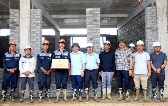 Đồng chí Hoàng Gia Long, Ủy viên Ban Thường vụ Tỉnh ủy, Phó Chủ tịch UBND tỉnh tặng quà cho các tổ thợ thi công dự án Trường Phổ thông nội trú liên cấp Xín Mần.
