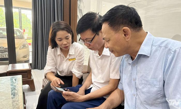 Tổ công nghệ số cộng đồng phường Quyết Thắng hỗ trợ người dân sử dụng các ứng dụng trên điện thoại thông minh.