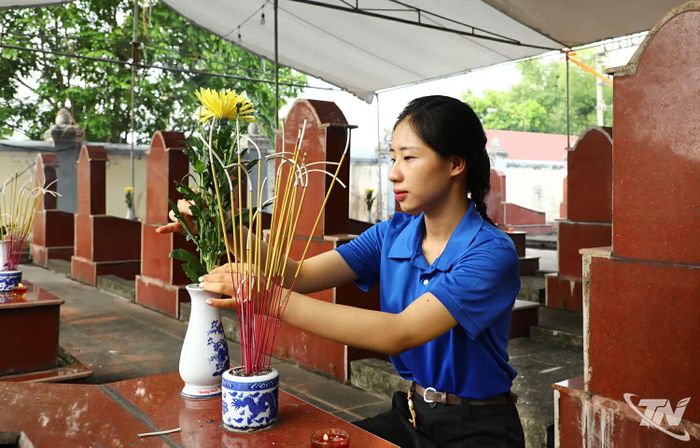 Đoàn viên thanh niên địa phương dâng hoa và thắp hương tại các phần mộ, trước giờ lực lượng chức năng làm nhiệm vụ.