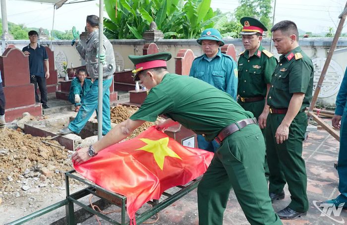 Quốc kỳ được phủ trang trọng lên tiểu sành hài cốt liệt sĩ trước khi bàn giao cho bộ phận pháp y thực hiện bước tiếp theo của quy trình.