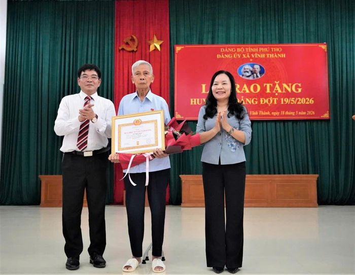 Ông Ngô Hữu Mai, Bí thư xã Vĩnh Thành trao huy hiệu Đảng cho các Đảng viên.