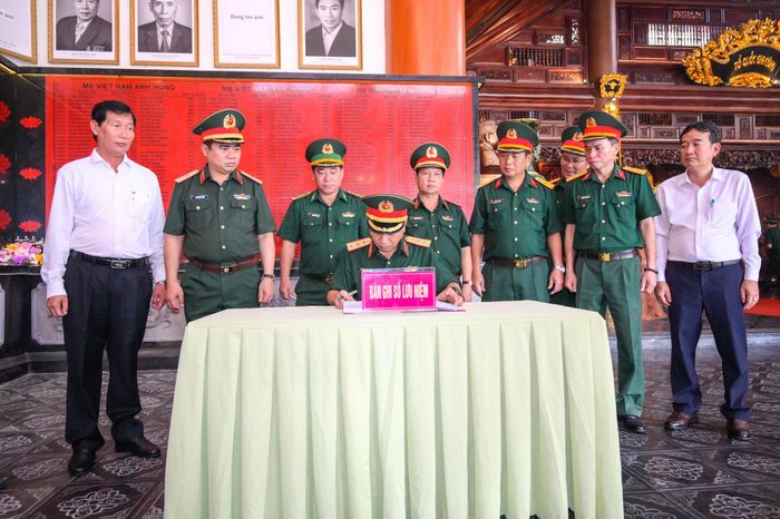 Thượng tướng Lê Quang Minh, Phó Chủ nhiệm Tổng cục Chính trị Quân đội nhân dân Việt Nam viết sổ lưu niệm tại Đền tưởng niệm Anh hùng liệt sĩ và Người có công tỉnh An Giang. Ảnh: Phương Vũ