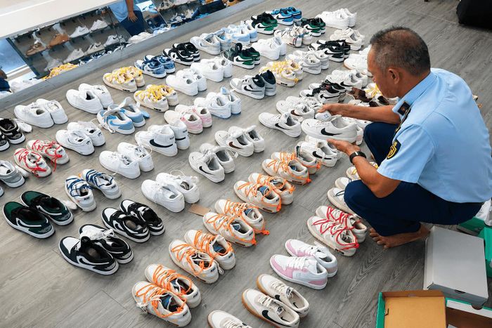 Lực lượng chức năng kiểm tra cơ sở kinh doanh sản phẩm có dấu hiệu xâm phạm quyền sở hữu trí tuệ. Ảnh: Viết Hồng
