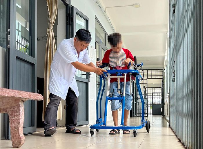 Y sĩ Huỳnh Thanh Huy kiên trì tập vật lý trị liệu cho trẻ bị khuyết tật nặng.