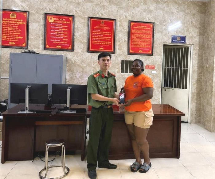 Tổ An ninh Công an phường Phú Thượng trao trả chiếc điện thoại cho chị Nnabuiife Chinzom Everister sau khi xác minh chủ sở hữu. Ảnh: PT.