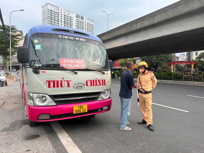 Lực lượng chức năng kiểm tra, xử lý xe khách dừng đón trả khách sai quy định trên phố Phạm Hùng. Ảnh: Vân Nhi
