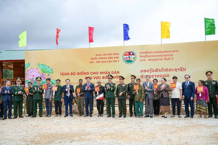 Đại tướng Phan Văn Giang và Đại tướng Khamliang Outhakaysone trao tặng bò giống cho các hộ dân có hoàn cảnh khó khăn khu vực biên giới Lào. Ảnh: Nam Trần