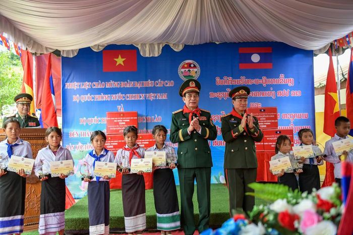 Bộ trưởng Bộ Quốc phòng hai nước tặng quà và trao 100 suất học bổng cho các học sinh của trường tiểu học Thông-năm-mun ở huyện Xaychamphone, tỉnh Bolykhamxay (Lào). Ảnh: Nam Trần