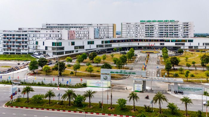 Toàn cảnh không gian bên ngoài của Bệnh viện Hữu nghị Việt Đức cơ sở 2 nhìn từ trên cao, nổi bật với quy mô rộng lớn và kiến trúc hiện đại. Khu vực cổng vào được thiết kế bề thế với hệ thống đường nội khu trải nhựa khang trang, phân làn rõ ràng và đan xen nhiều khoảng không gian xanh, bãi cỏ rộng rãi. Khi hoàn thiện quy mô 1.000 giường bệnh, Bệnh viện sẽ có khả năng tiếp nhận hàng nghìn người đến khám và điều trị mỗi ngày, góp phần giảm tải cho cơ sở chính tại Hà Nội và nâng cao năng lực điều trị ngoại khoa cho khu vực phía Bắc. 