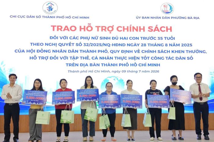  TS.BS Huỳnh Minh Chín, Phó giám đốc Sở Y tế TP.HCM (ngoài cùng bên phải) trao quà và tiền thưởng cho 7 phụ nữ tiêu biểu sinh con thứ 2 trước 35 tuổi. Ảnh: Nguyễn Thuận. 