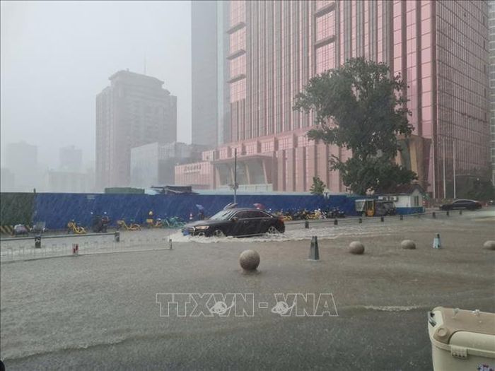 Các phương tiện lưu thông chậm qua đoạn đường ngập sau trận mưa lớn do hoàn lưu bão Maysak gây ra. Ảnh: Quang Hưng, PV TTXVN tại Trung Quốc