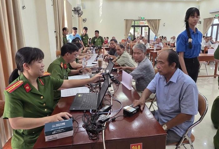 Cán bộ công an hướng dẫn kê khai thông tin và thực hiện các thủ tục để thu nhận mẫu sinh phẩm ADN thân nhân liệt sĩ tại Huế. Ảnh: CA