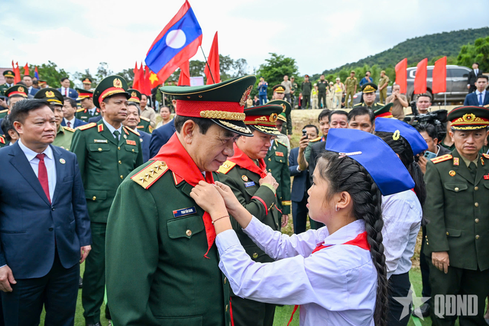 Học sinh Trường Tiểu học Thongnammoun đeo khăn quàng đỏ cho Đại tướng Phan Văn Giang.