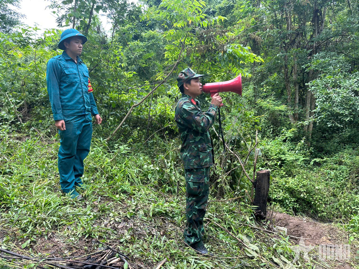 Lực lượng chức năng phát loa thông báo nguy hiểm, cảnh báo người dân không đi vào khu vực xử lý bom mìn, vật nổ.