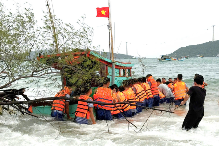 Cán bộ, chiến sĩ Vùng 5 Hải quân nỗ lực cứu kéo tàu cá của ngư dân ra khỏi nơi mắc cạn. Ảnh: VĂN ĐỊNH