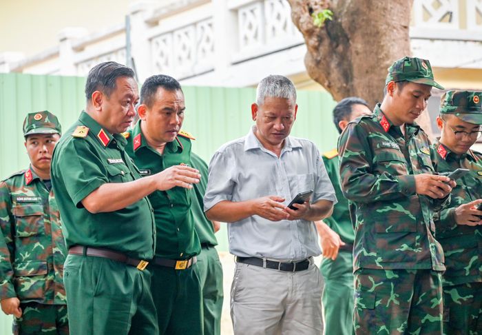  Thiếu tướng Nguyễn Thành Trung trao đổi với kiến trúc sư Nguyễn Xuân Thắng, sáng 9-7. Ảnh: MẠNH THẮNG 