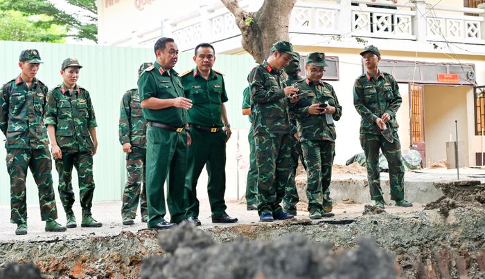 Thiếu tướng Nguyễn Thành Trung, Chính ủy Bộ Tư lệnh TPHCM (hàng đầu, thứ nhất từ trái qua) chỉ đạo tại hiện trường mở rộng tìm kiếm, khai quật hài cốt liệt sĩ tại Công viên Lê Thị Riêng, ngày 9-7