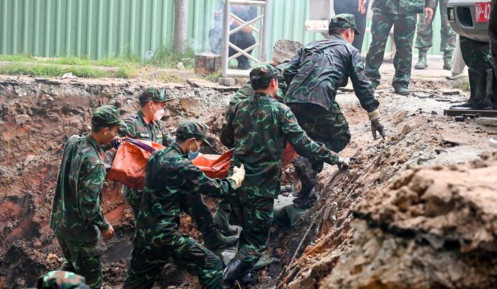 Một hài cốt được các lực lượng khai quật đưa đến phòng lấy mẫu, lưu mẫu ADN, chiều 9-7