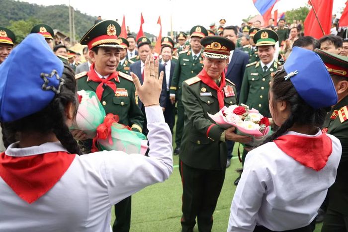 Học sinh Trường Tiểu học Thongnammoun đeo khăn quàng đỏ cho Đại tướng Phan Văn Giang. Ảnh: Song Ngư.