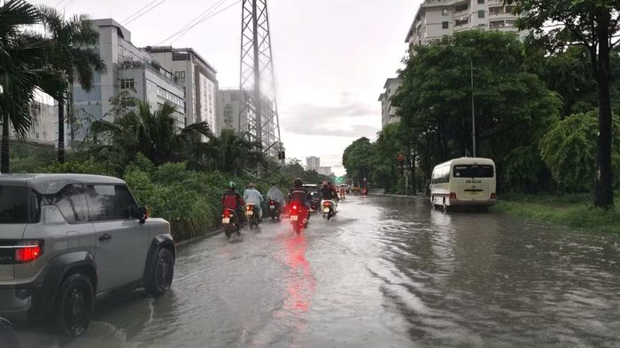  Nhiều phương tiện di chuyển chậm qua đoạn đường ngập cục bộ sau cơn mưa lớn. 