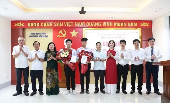 Bà Nguyễn Thị Nguyệt, Phó Chủ tịch UBND tỉnh Hà Tĩnh và ông Bùi Nhân Sâm, Giám đốc Sở GD&ĐT cùng đại diện lãnh đạo sở ban ngành tặng hoa chúc mừng em Thái Văn Gia Kiên và em Võ Sỹ Quốc Anh.