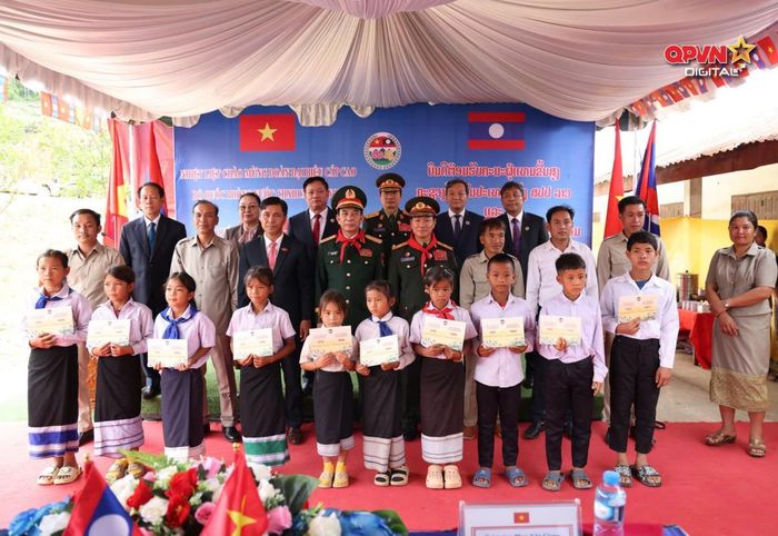 Đại tướng Phan Văn Giang và Đại tướng Khăm Liêng - Ụ Thạ Cay Sỏn trao học bổng tặng học sinh Trường Tiểu học Thông Năm Mun, huyện Xay Chăm Pon, tỉnh Bô Ly Khăm Xay (Lào). Ảnh: QPVN
