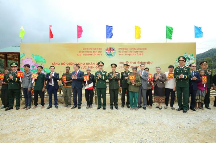 Đại tướng Phan Văn Giang và Đại tướng Khăm Liêng - Ụ Thạ Cay Sỏn cùng các đại biểu trao bò giống tặng các hộ dân có hoàn cảnh khó khăn tỉnh Bô Ly Khăm Xay (Lào). Ảnh: Khánh Toàn