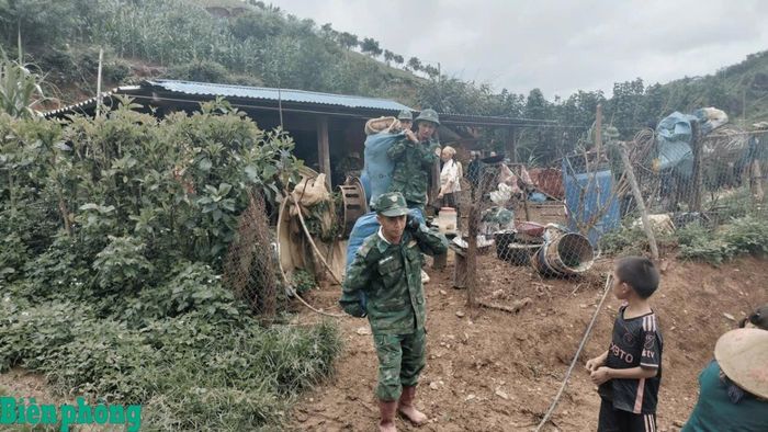 Cán bộ, chiến sĩ Đồn Biên phòng Chiềng Tương, Bộ đội Biên phòng tỉnh Sơn La giúp nhân dân di chuyển đồ đạc đến nơi an toàn. Ảnh: Quàng Hùng