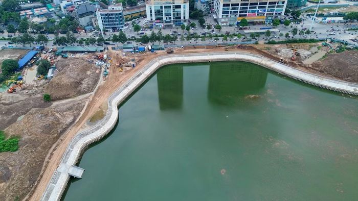 Ghi nhận của phóng viên Tiền Phong cho thấy phần lớn khối lượng đào đắp đã hoàn thành, các đơn vị thi công tập trung hoàn thiện kè hồ, đường dạo, hạ tầng kỹ thuật và chỉnh trang cảnh quan. Máy xúc, xe lu cùng nhiều công nhân vẫn làm việc tại một số khu vực để đẩy nhanh tiến độ hoàn thiện công trình.