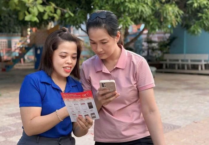  Tình nguyện viên đội hình Mùa hè số đặc khu Côn Đảo hướng dẫn người dân cài đặt app trên điện thoại thông minh. 