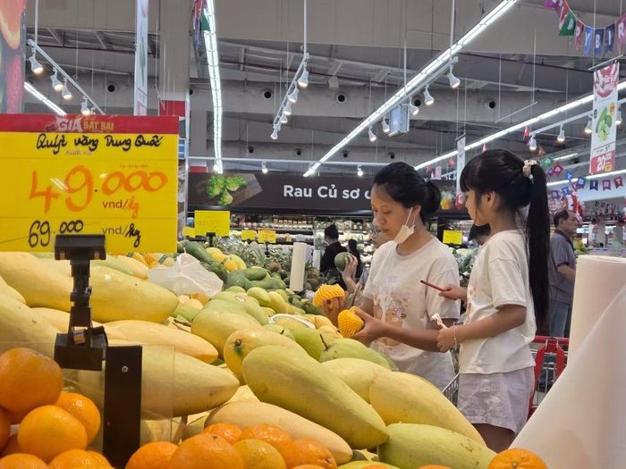 Người tiêu dùng mua sắm hàng hóa thiết yếu tại Hà Nội trong bối cảnh giá xăng giảm sâu, kỳ vọng áp lực chi tiêu được hạ nhiệt tương ứng.
