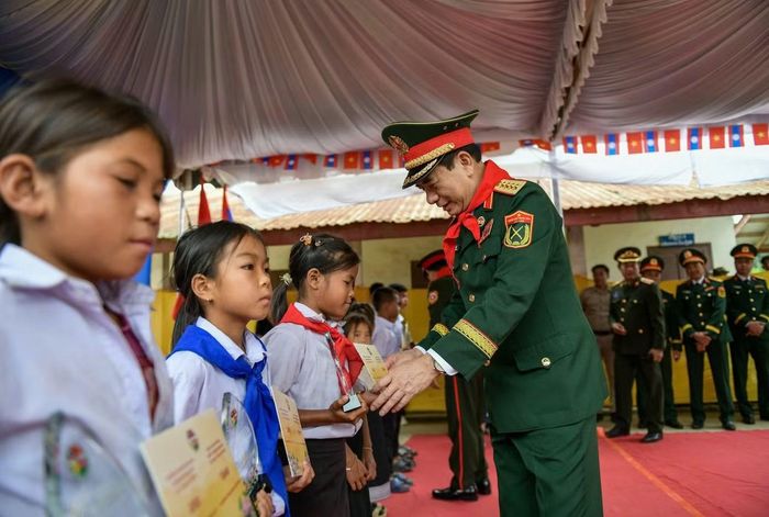 Đại tướng Phan Văn Giang trao học bổng tặng các em học sinh. (Ảnh: Nam Trần).