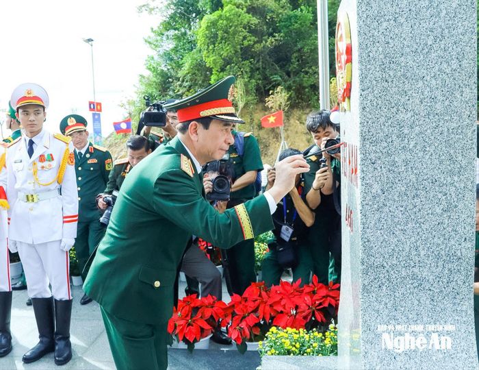 Đại tướng Phan Văn Giang tô son cột mốc chủ quyền. Ảnh: Hải Thượng