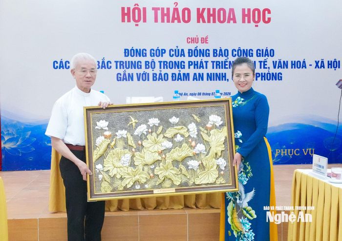 Đồng chí Võ Thị Minh Sinh – Phó Bí thư Tỉnh ủy, Chủ tịch Ủy ban MTTQ Việt Nam tỉnh Nghệ An trao tặng Trung ương Ủy ban Đoàn kết Công giáo Việt Nam bức tranh sen. Ảnh: Mai Hoa